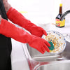 A pair of red silicone scrubbing gloves are shown dipping into a stainless steel sink for dishwashing.
