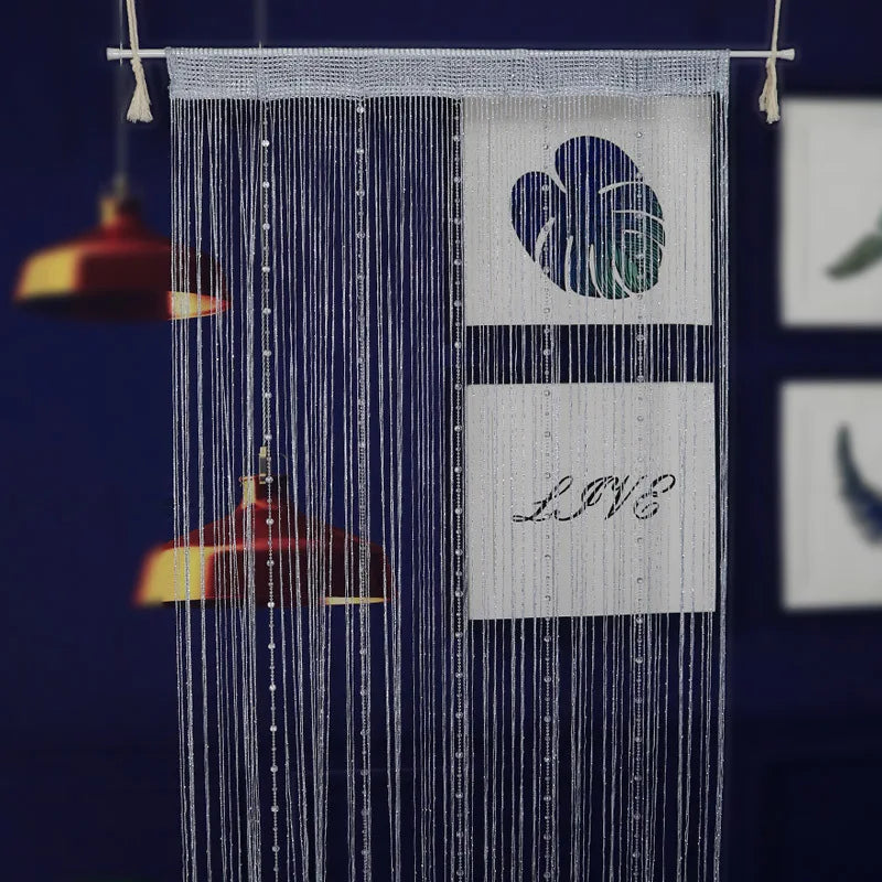 A vertical string curtain made of blue beads hangs, featuring a heart design and the word LOVE.
