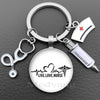 Silver nurse keychain featuring a glass dome charm and a medical syringe accessory.