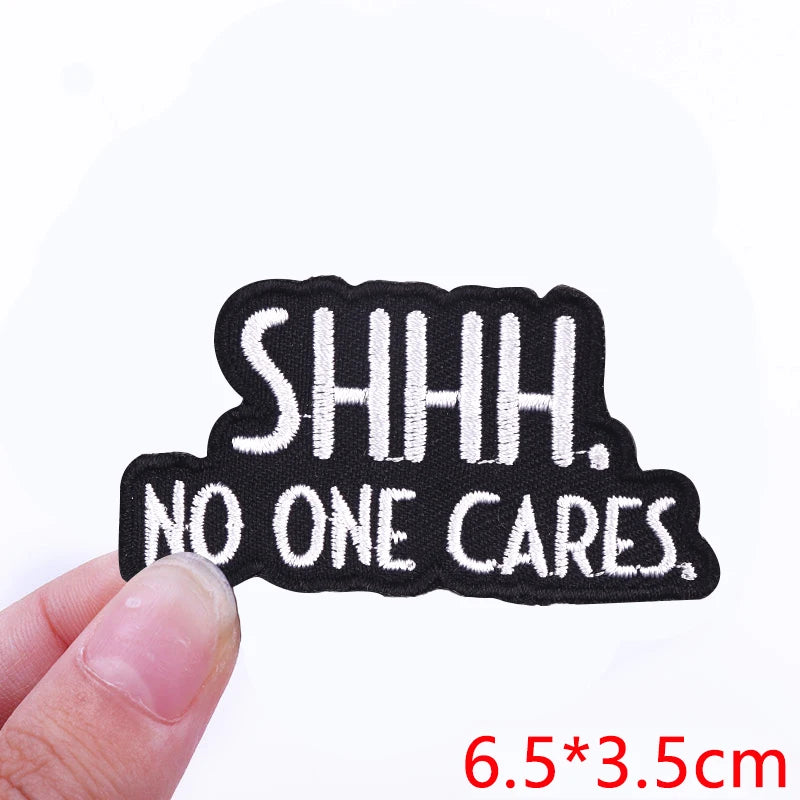 Black embroidered iron-on letter patch with the text SHHH. NO ONE CARES.