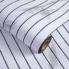 Roll of 3D grille pattern peel-and-stick wallpaper with black lines on a white background