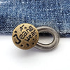 A round brass button with the text Jeans wear engraved on it, resting on a blue denim fabric.