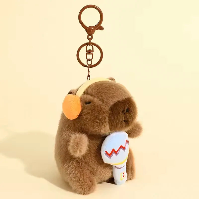 A brown capybara plush toy attached to a wooden keyring.