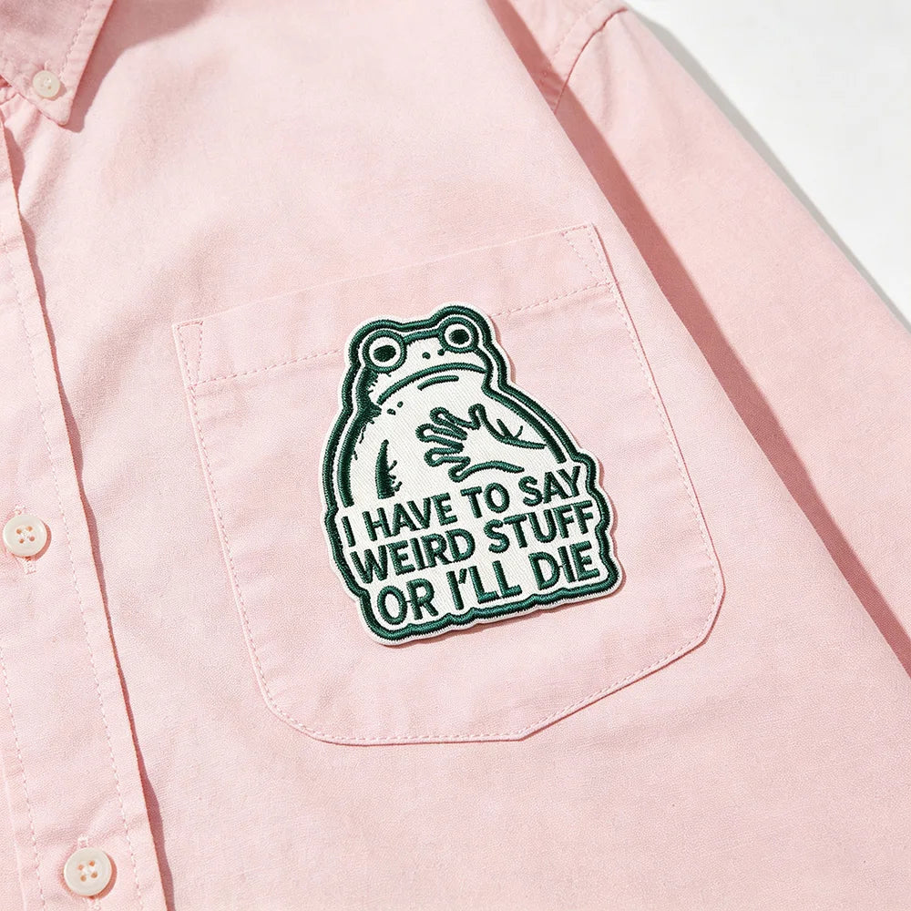 A pink shirt features an embroidered patch of a frog saying I have to say weird stuff or I'll die.