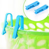 Blue plastic clips used to hold garbage bags or snack bags on a trash can or basket.
