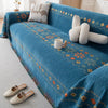 A deep blue bohemian jacquard sofa cover featuring geometric patterns and cream-colored decorative pillows.