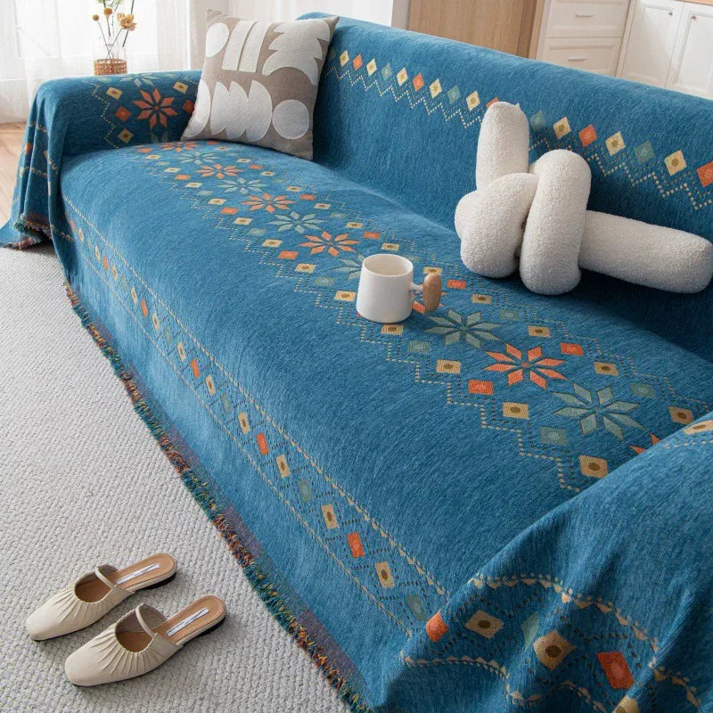 A deep blue bohemian jacquard sofa cover featuring geometric patterns and cream-colored decorative pillows.