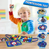A smiling toddler holds up a colorful Montessori busy board for sensory and motor skill development.