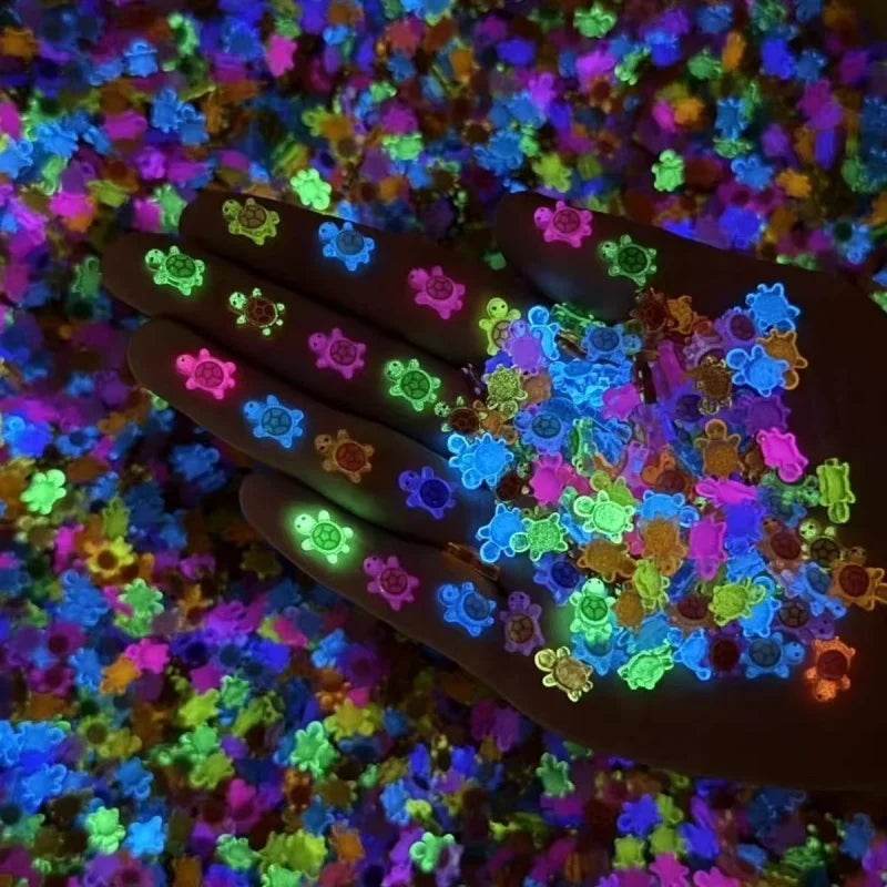 A hand holds a collection of glow-in-the-dark mini turtle figurines scattered on a colorful surface.