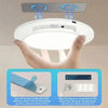 A hand holds a white motion sensor ceiling light, demonstrating how to attach the magnetic component for charging.