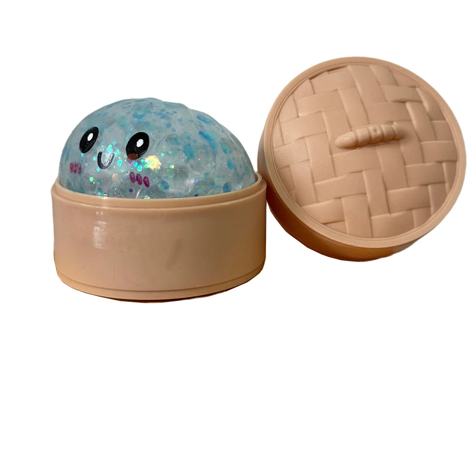 Runde, durchscheinende blaue Glitzer-Squishy-Spielzeug in einem beige Behälter mit passender Deckel.