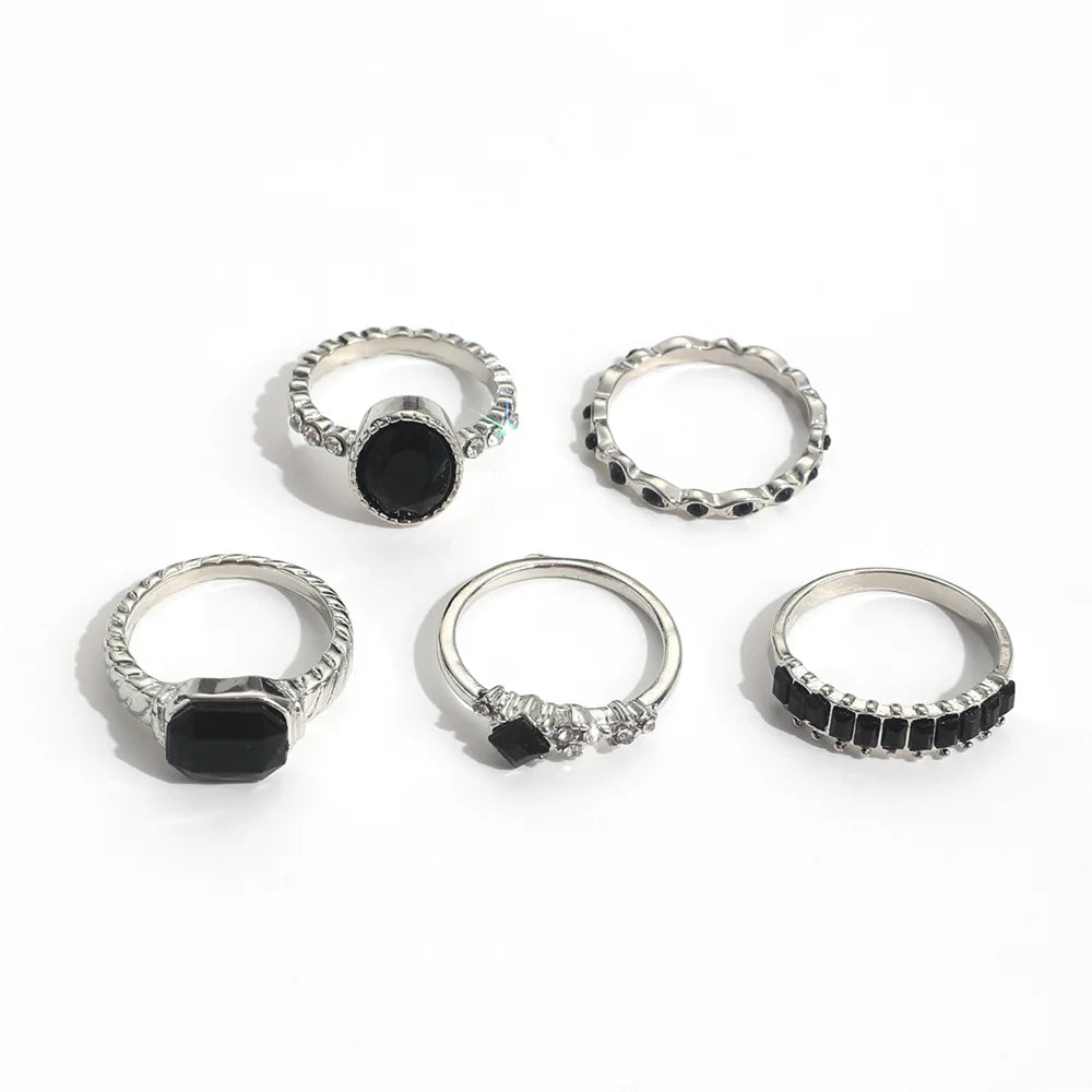 A set of vintage black crystal rings, including a simple band and a ring with a black oval stone.
