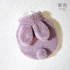 A soft purple plush rabbit hot water bottle with a flannel cover.
