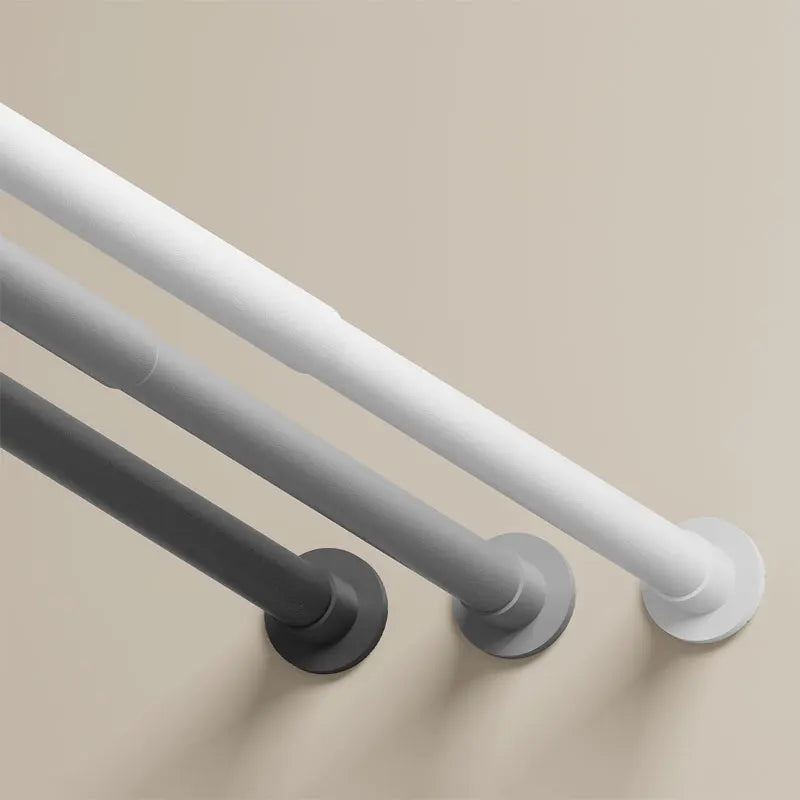 A close-up view of a modern, adjustable stainless steel tension shower curtain rod mounted on a wall.