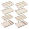 A set of light beige velvet jewelry organizer trays with various detachable compartments.