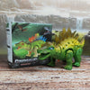 A green dinosaur toy, Stegosaurus, is displayed next to its packaging box.
