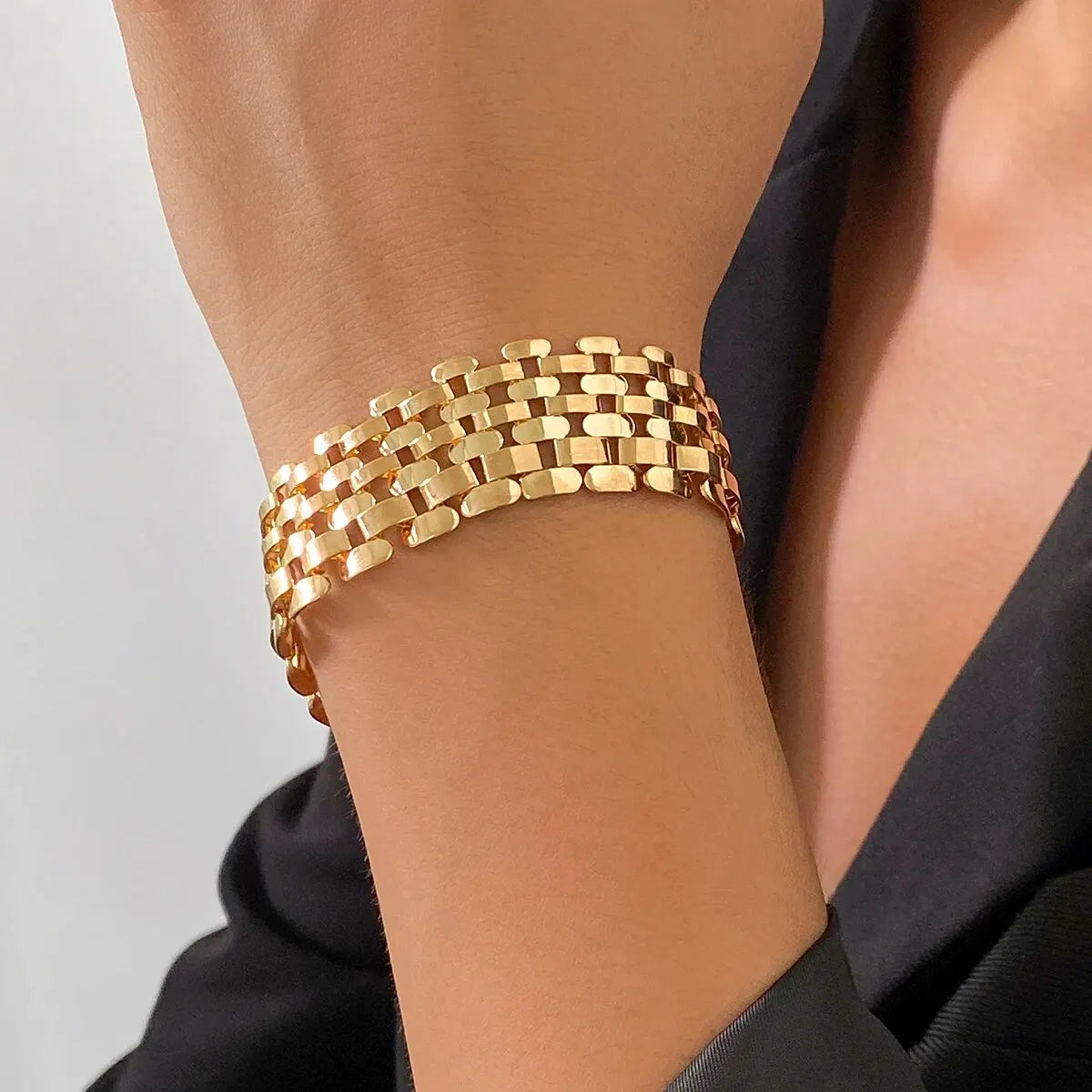 Bracelet chunky maillons cubains doré porté au poignet.