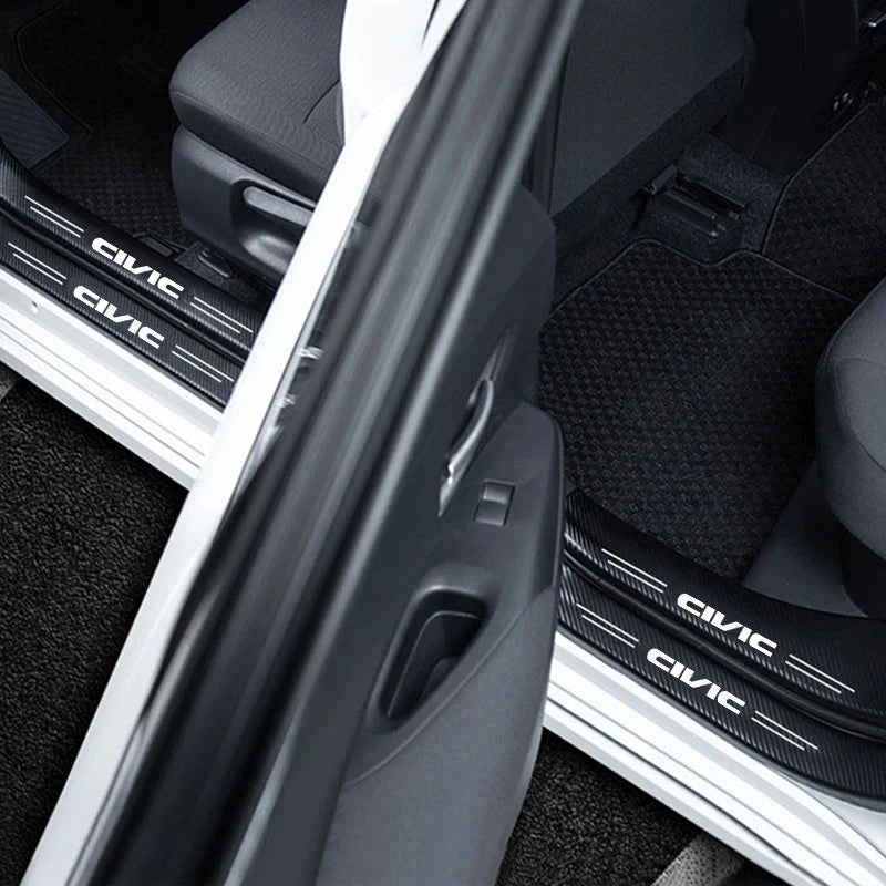 Close-up view of carbon fiber door sill protector stickers installed on a vehicle interior.