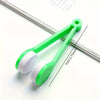 A green eyeglass cleaning kit with a handle and two white microfiber cleaning pads is shown on a white background.