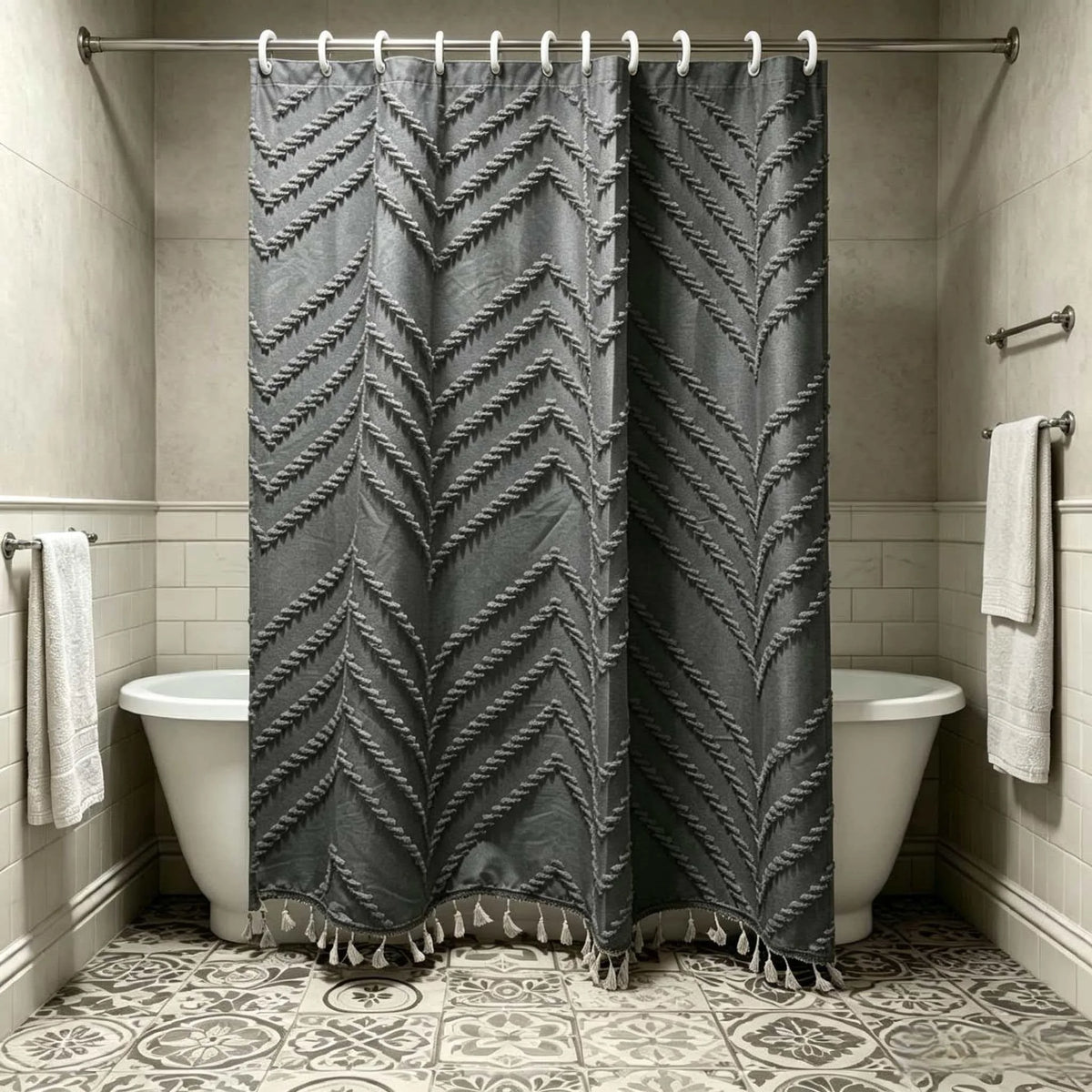 A dark gray bohemian floral cutout tassel shower curtain hanging on a rod in a bathroom.