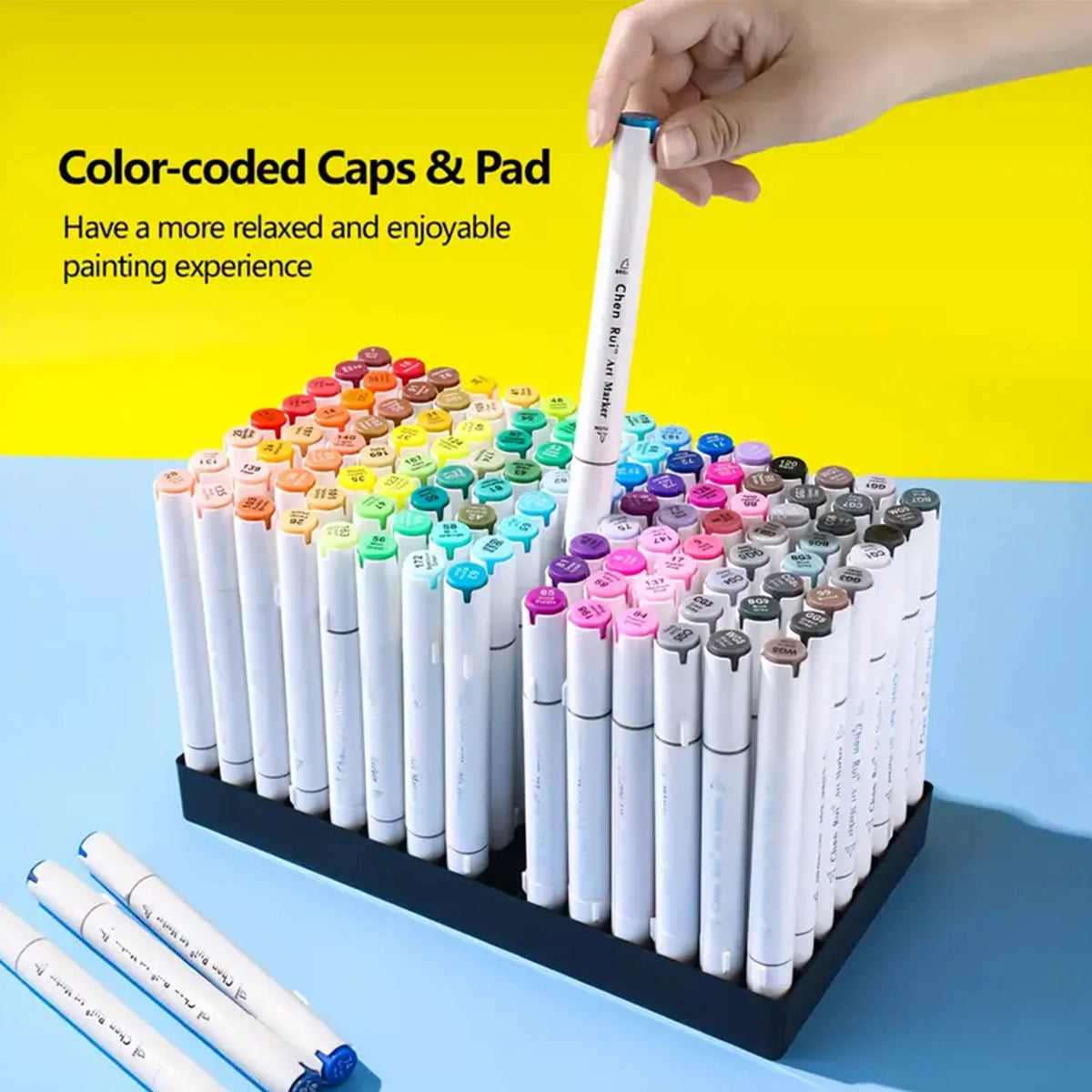 A collection of color-coded caps and pads for alcohol art markers displayed in a row on a black tray.