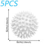 A spherical white laundry ball with numerous protrusions shown next to a measurement scale.