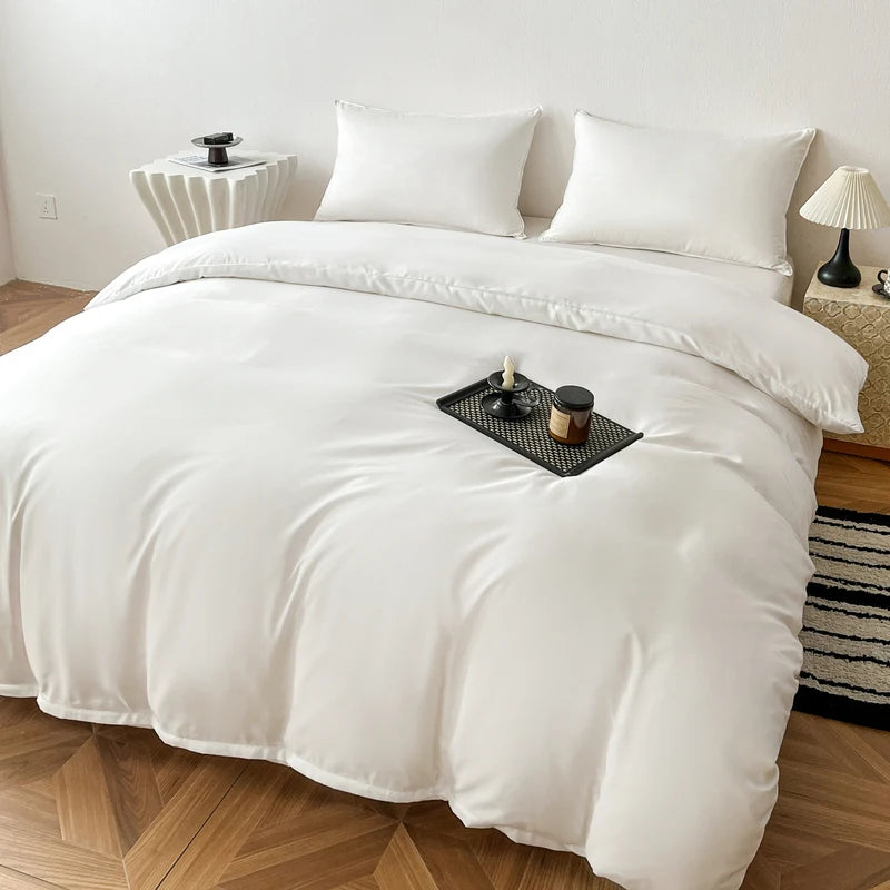 A white washed cotton brushed duvet cover with a smooth drape is displayed on a bed with white pillows and natural wood floor