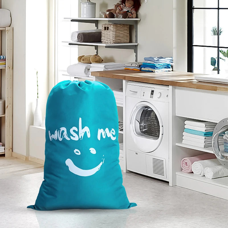 A bright teal drawstring laundry bag resting on a light floor in a kitchen area with laundry appliances visible.