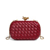 A deep red woven clutch bag with a gold chain strap, shown against a white background.