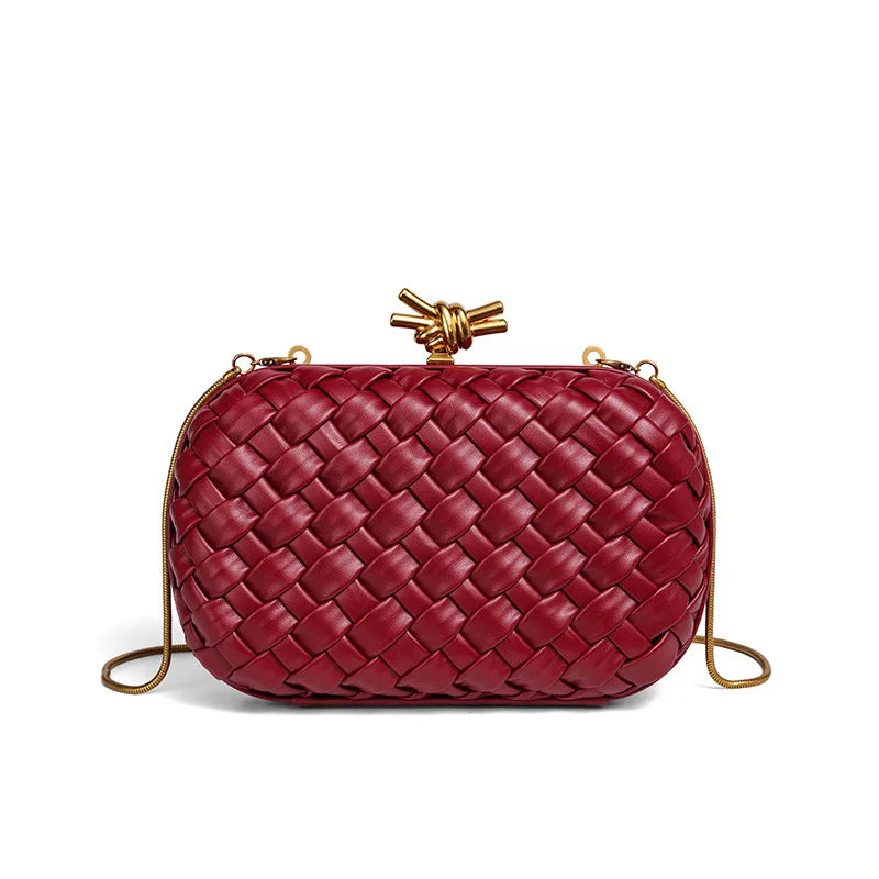 A deep red woven clutch bag with a gold chain strap, shown against a white background.