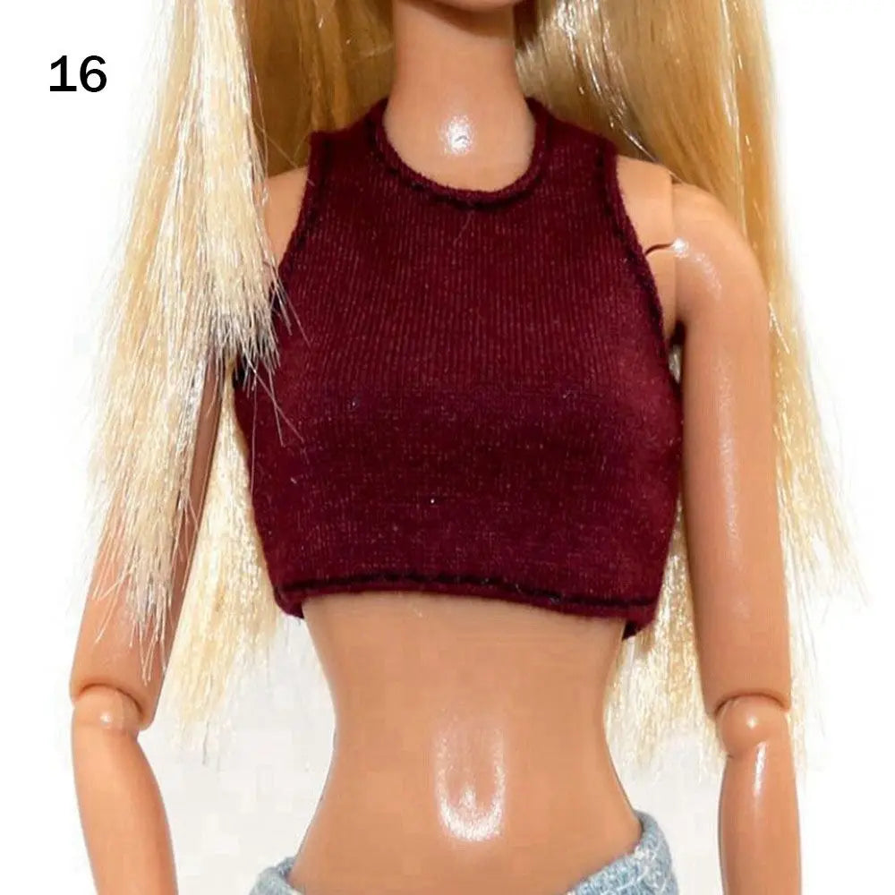 A fashion doll wearing a dark burgundy sleeveless top and light blonde hair.
