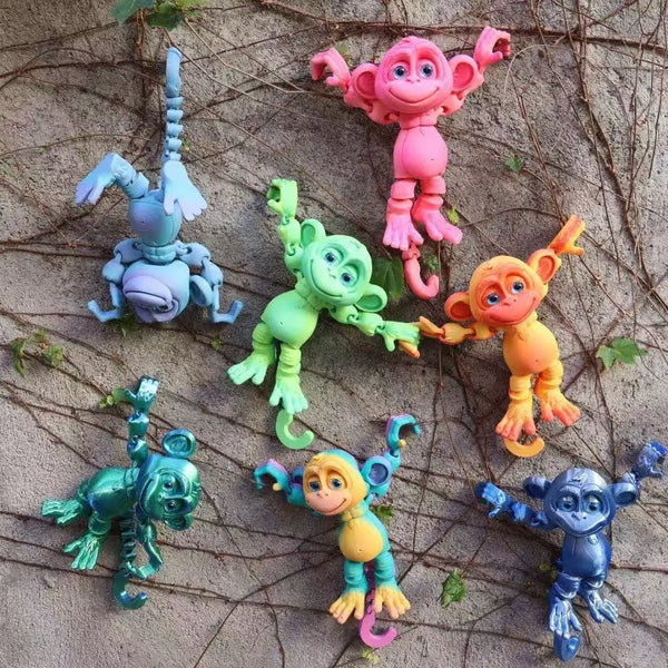 A collection of colorful 3D printed monkey statues in various poses and colors.