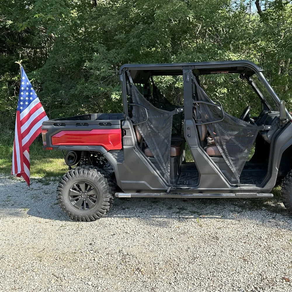 A gray truck with a custom open-air bed and a flag pole holder mounted on the tailgate, parked on gravel.