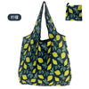 A dark blue nylon reusable shopping tote bag with a yellow and green leaf pattern.