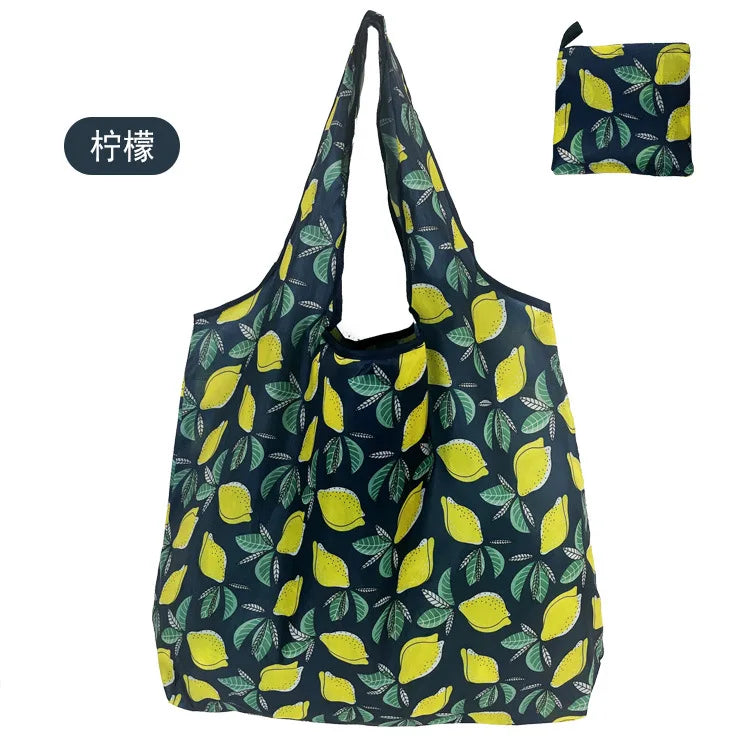 A dark blue nylon reusable shopping tote bag with a yellow and green leaf pattern.