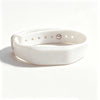 A white silicone wristband with a silver ring and small holes for access control.