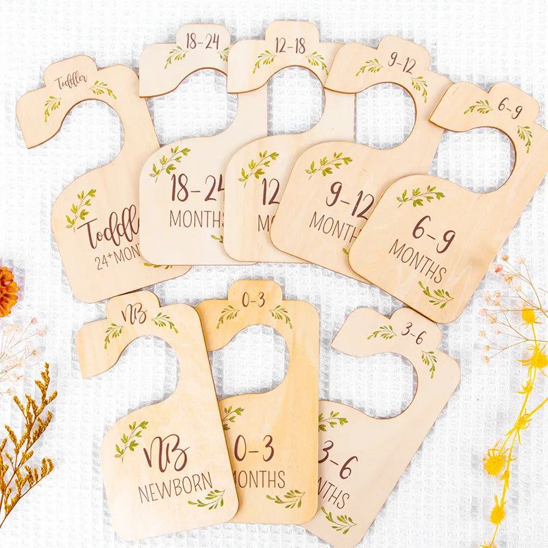 A set of eight wooden baby closet dividers showing size organizers for newborn to 24 months.