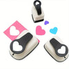 A set of three heart-shaped paper punches in black and beige for crafting.