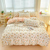 A light floral patterned bedding set featuring peach and green tones with a white background.