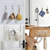 Self-adhesive rotating wall hooks for storage displayed on a white wall and wooden surface.