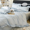 A set of light blue bedding including a duvet cover, pillowcases, and pillow core with black dot print.