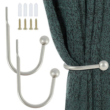 A set of two silver U-shaped tieback hooks and four brass screws shown next to a dark teal fabric.