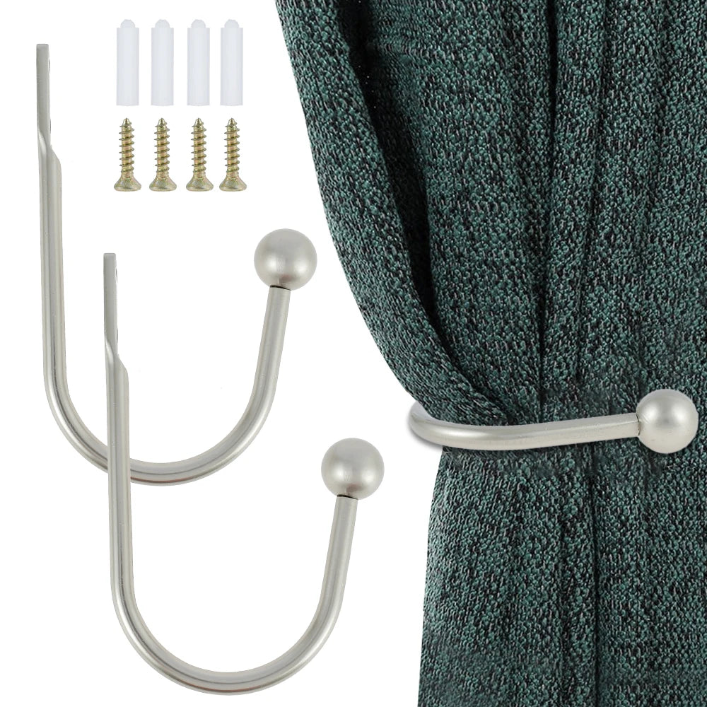 A set of two silver U-shaped tieback hooks and four brass screws shown next to a dark teal fabric.