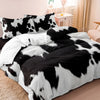 Black and white cow print duvet cover set with matching pillowcases on a bed.
