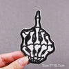 Black and white embroidered skull horror patch on a hand