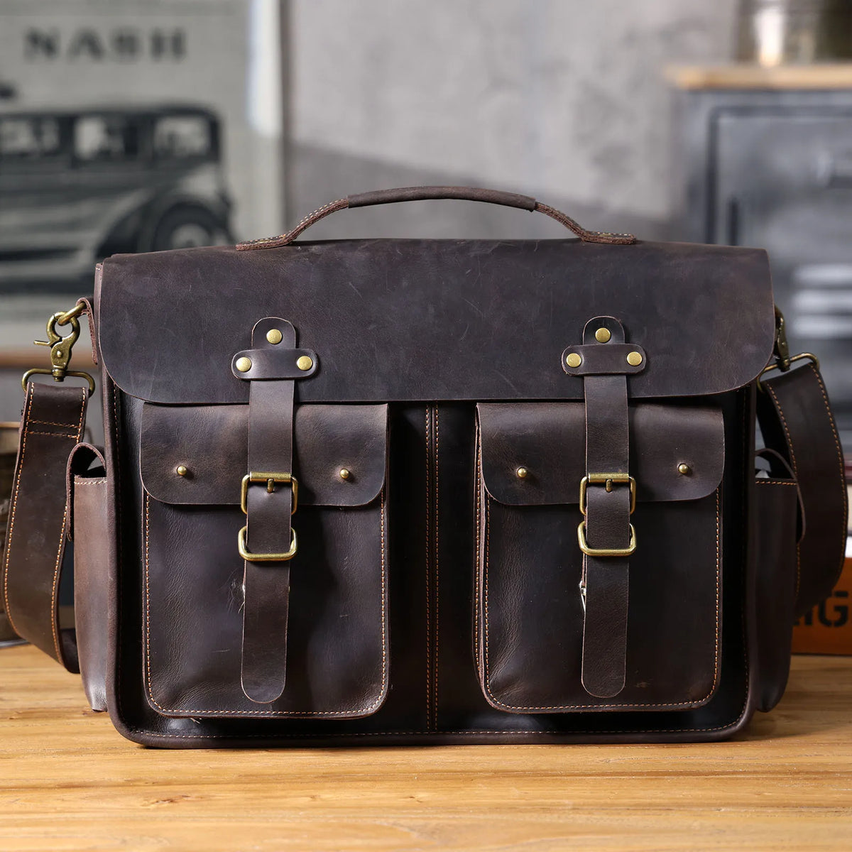 Dunkelbraunes Vintage-Ledertasche mit Messing-Hardware auf Holzoberfläche.