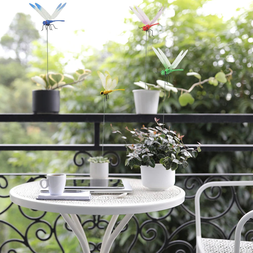 A display of lifelike dragonfly clips in various colors decorating potted plants on a cafe table.