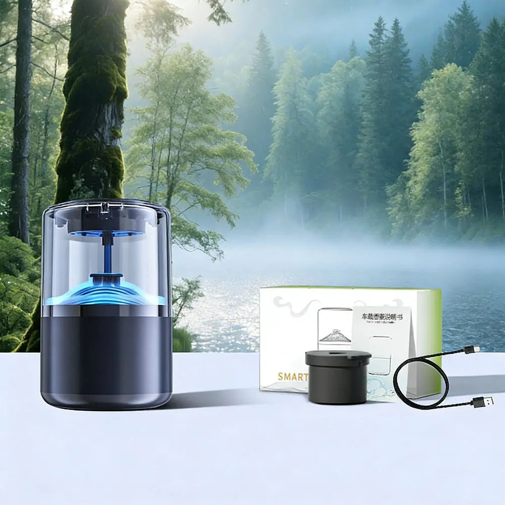 A black smart car diffuser with blue ambient light is shown on a white surface next to its packaging in a misty forest settin