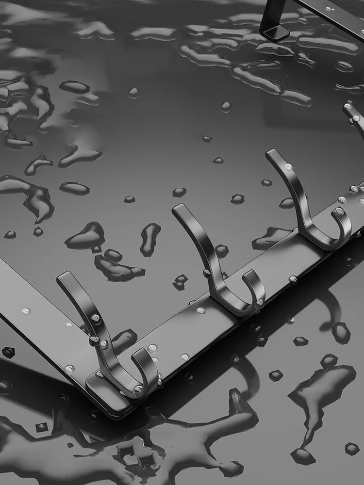 A close-up view of a black over-the-door organizer rack with eight hooks resting on a dark, reflective surface.
