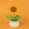 Handcrafted crochet sunflower with green leaves growing in a white pot
